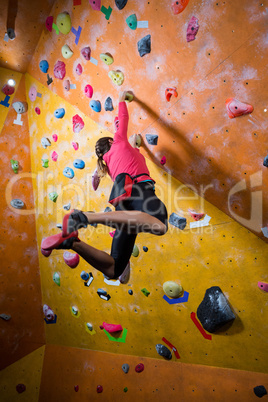 Determined woman practicing rock climbing