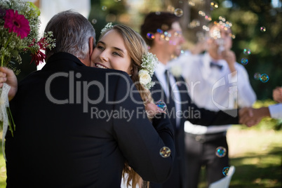 Father embracing his daughter in park