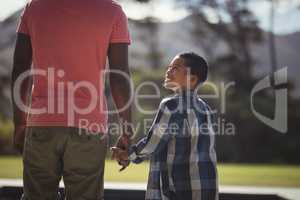 Father and son standing near poolside