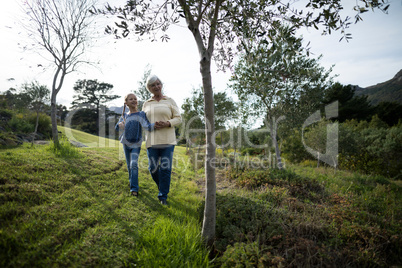 Grandmother and granddaughter walking together in the garden