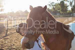 Rider boy caressing a horse in the ranch