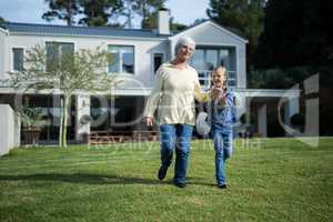 Granddaughter and grandmother waking together in garden