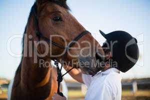 Rider boy caressing a horse in the ranch