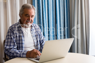 Senior man using laptop while sitting at table