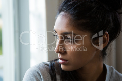 Close-up of woman looking through window