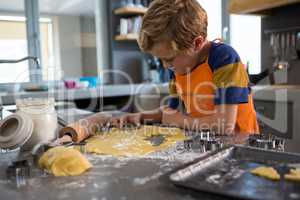 Boy making shapes from pastry cutter
