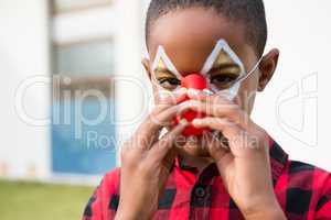 Close up portrait of boy wearing clown nose