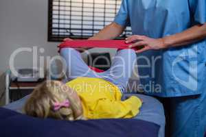 Female physiotherapist assisting a girl patient while exercising