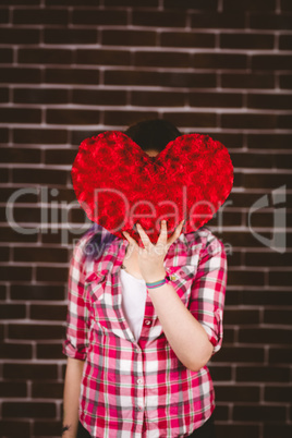 Woman hiding face from heart shape