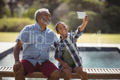 Grandson and grandfather taking selfie with mobile phone