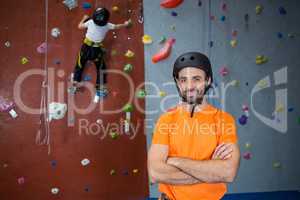 Trainer standing with arms crossed in fitness studio