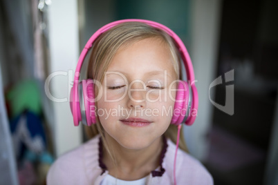 Girl listening to music on headphones at home