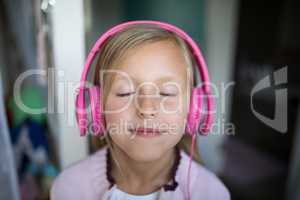 Girl listening to music on headphones at home