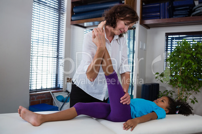 Physiotherapist giving leg massage to a girl patient