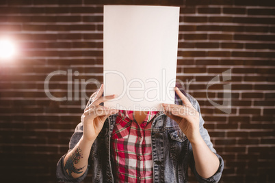 Woman hiding face from blank sheet