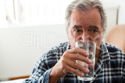 Senior man drinking water in nursing home