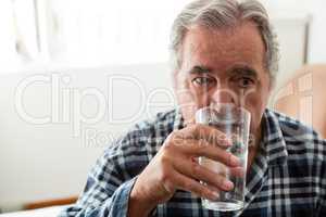 Senior man drinking water in nursing home