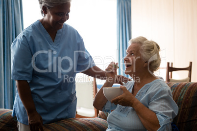 Senior woman talking to nurse while having food