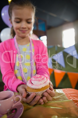 Birthday girl holding a cupcake