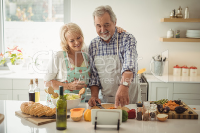 Senior couple preparing meal in kitchen