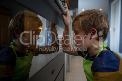 Side view of boy looking at oven