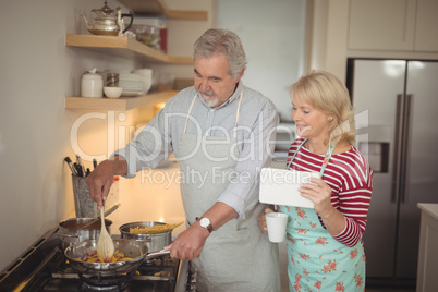 Senior couple preparing food in kitchen