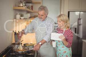 Senior couple preparing food in kitchen
