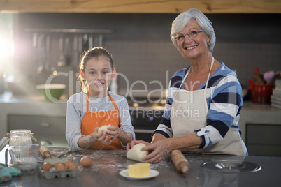 Grandmother and granddaughter kneading dough