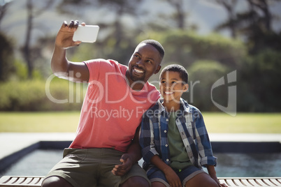 Father and son taking selfie with mobile phone