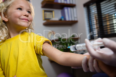 Physiotherapist injecting girl patient