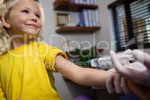 Physiotherapist injecting girl patient