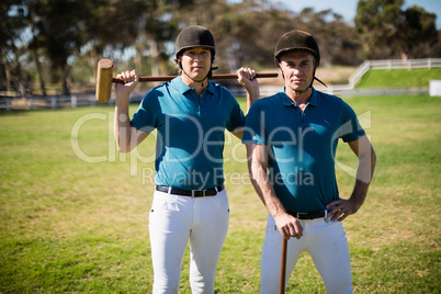 Two male jockeys standing in the ranch