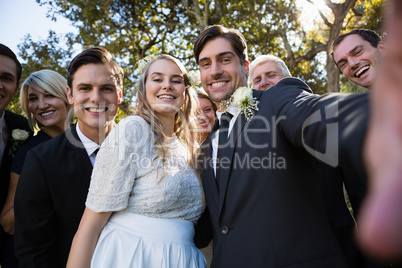 Happy couple posing with guests during wedding
