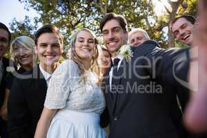 Happy couple posing with guests during wedding