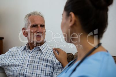 Doctor consoling senior man in nursing home