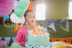 Birthday girl blowing birthday candles