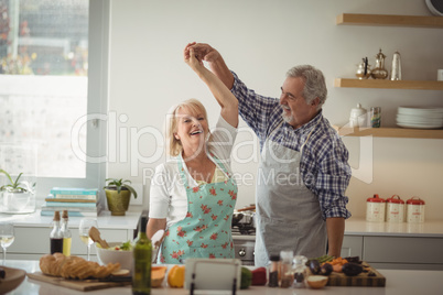 Senior couple dancing in kitchen