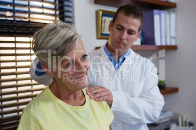 Physiotherapist examining neck of a female patient