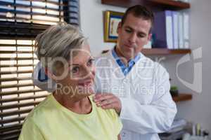 Physiotherapist examining neck of a female patient