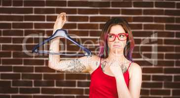 Confused woman holding hanger