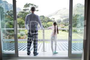 Father and daughter standing together in balcony