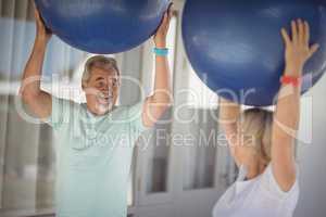 Senior couple exercising with exercise ball