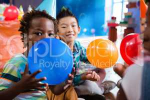 Portrait of children playing with colorful balloon