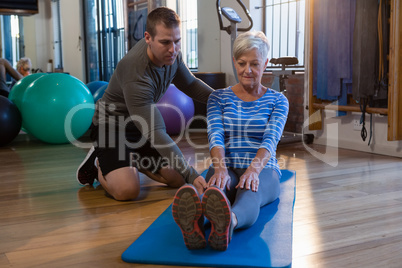 Physiotherapist assisting senior woman in exercise