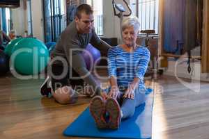 Physiotherapist assisting senior woman in exercise
