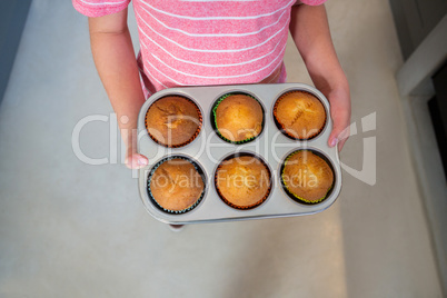 Mid section of boy holding muffins