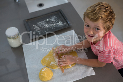Portrait of boy rolling dough