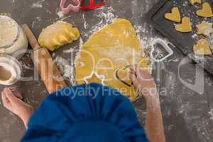 Cropped hands of boy preparing cookies in kitchen