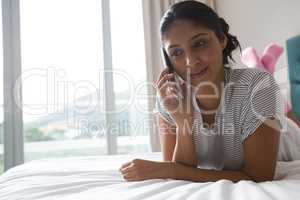 Woman using phone on bed
