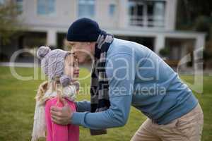 Father kissing her daughter in garden
